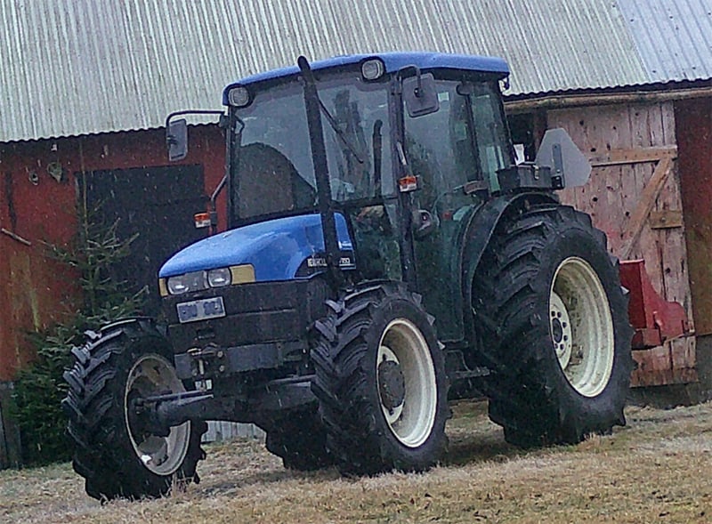 Jordbrukstraktor, blå New Holland TN65D 4WD stulen på gård väster om Älmhult